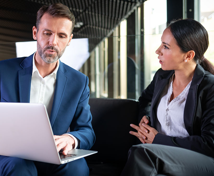 Business people with laptop in modern office building talking about project